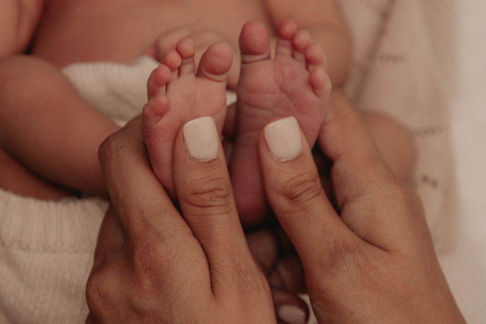 Un bébé assis dans l'herbe qui éclate de rire.